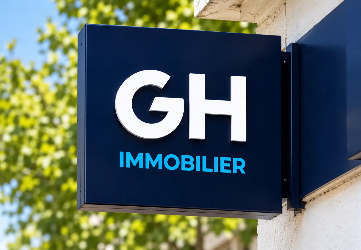 Enseigne drapeau GH Immobilier vue depuis la rue en gros plan